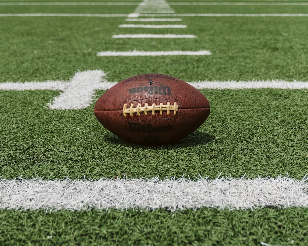 American football on yard lines of a green gridiron field