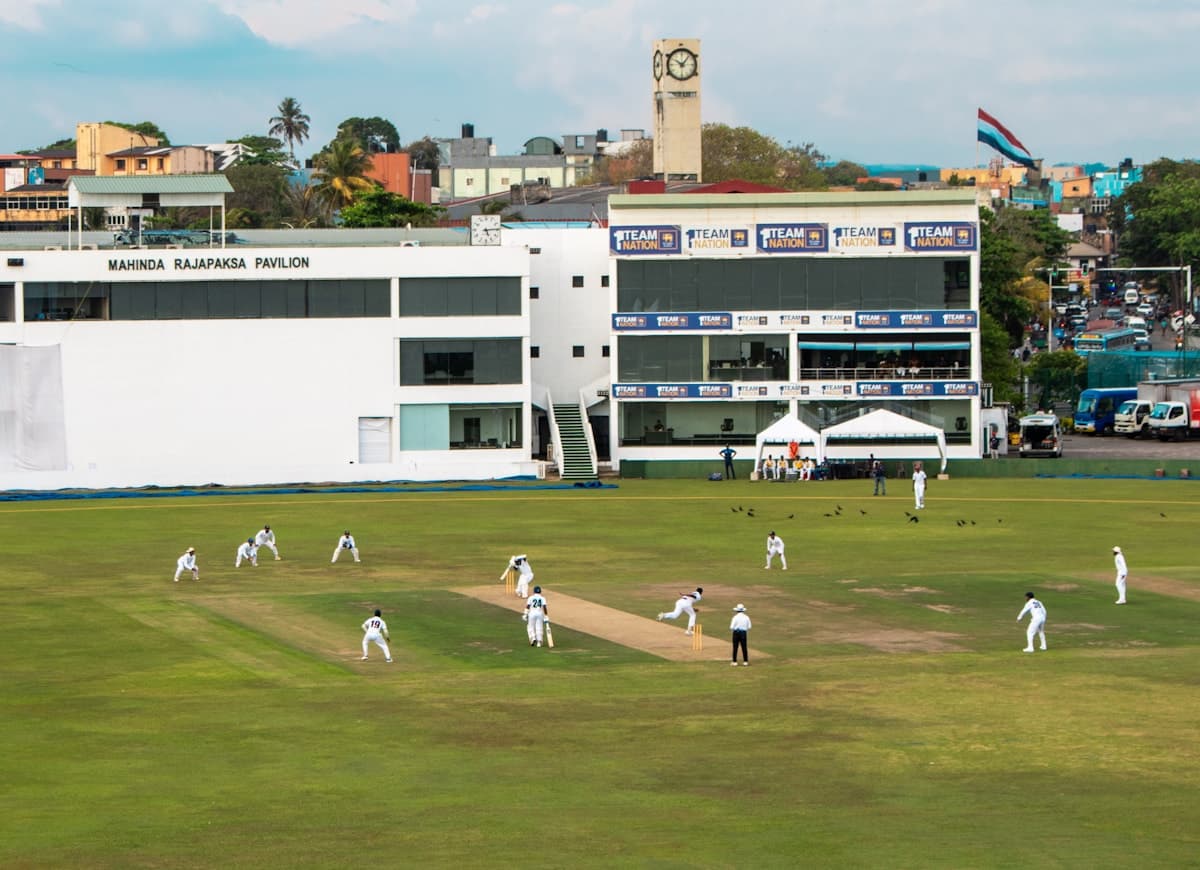 Cricket bat, ball, and stumps on a grass cricket field