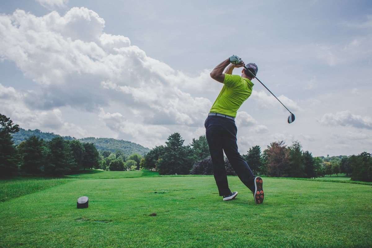 Golfer mid-swing on a sunny golf course